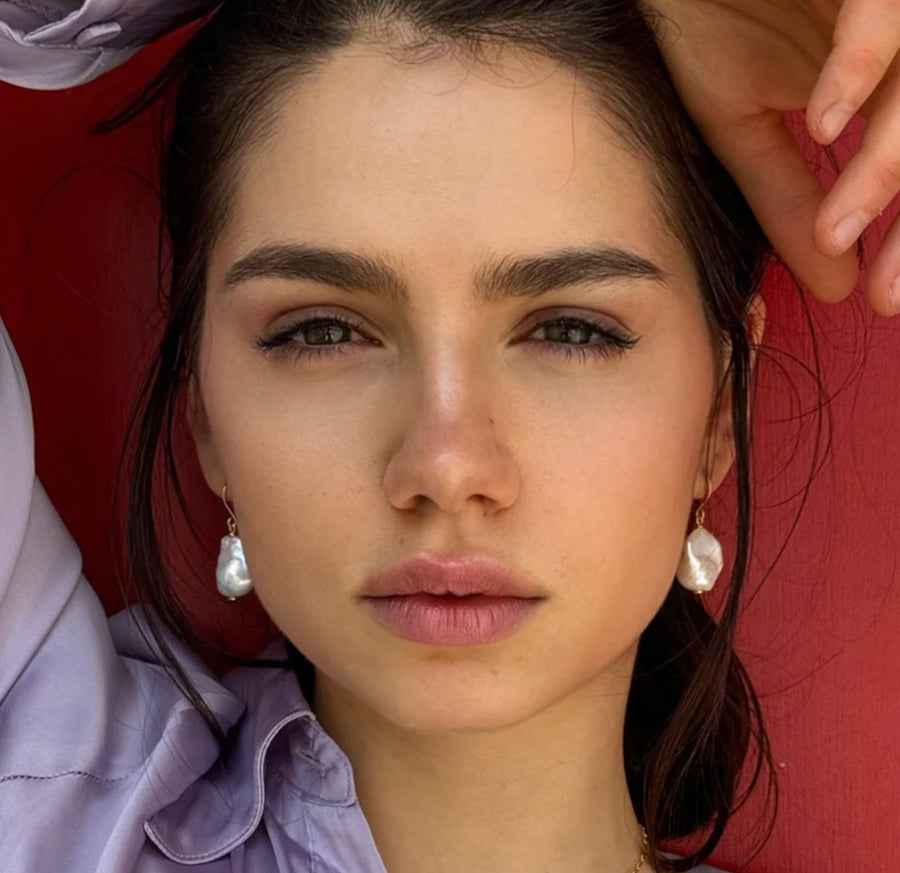 Image of a dark haired girl wearing Leoni & Vonk pearl earrings