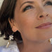Dark haired woman wearing Leoni & Vonk earrings and looking up