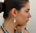 Dark haired girl in profile looking to the left of the image and wearing Leoni & Vonk baroque pearl earrings.