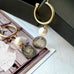 Leoni & Vonk gold hoop, pearl and antique Queen Victoria earrings on a vintage postcard and with a black box.