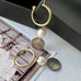 Leoni & Vonk gold hoop, pearl and antique Queen Victoria earrings on a vintage postcard and with a black box.