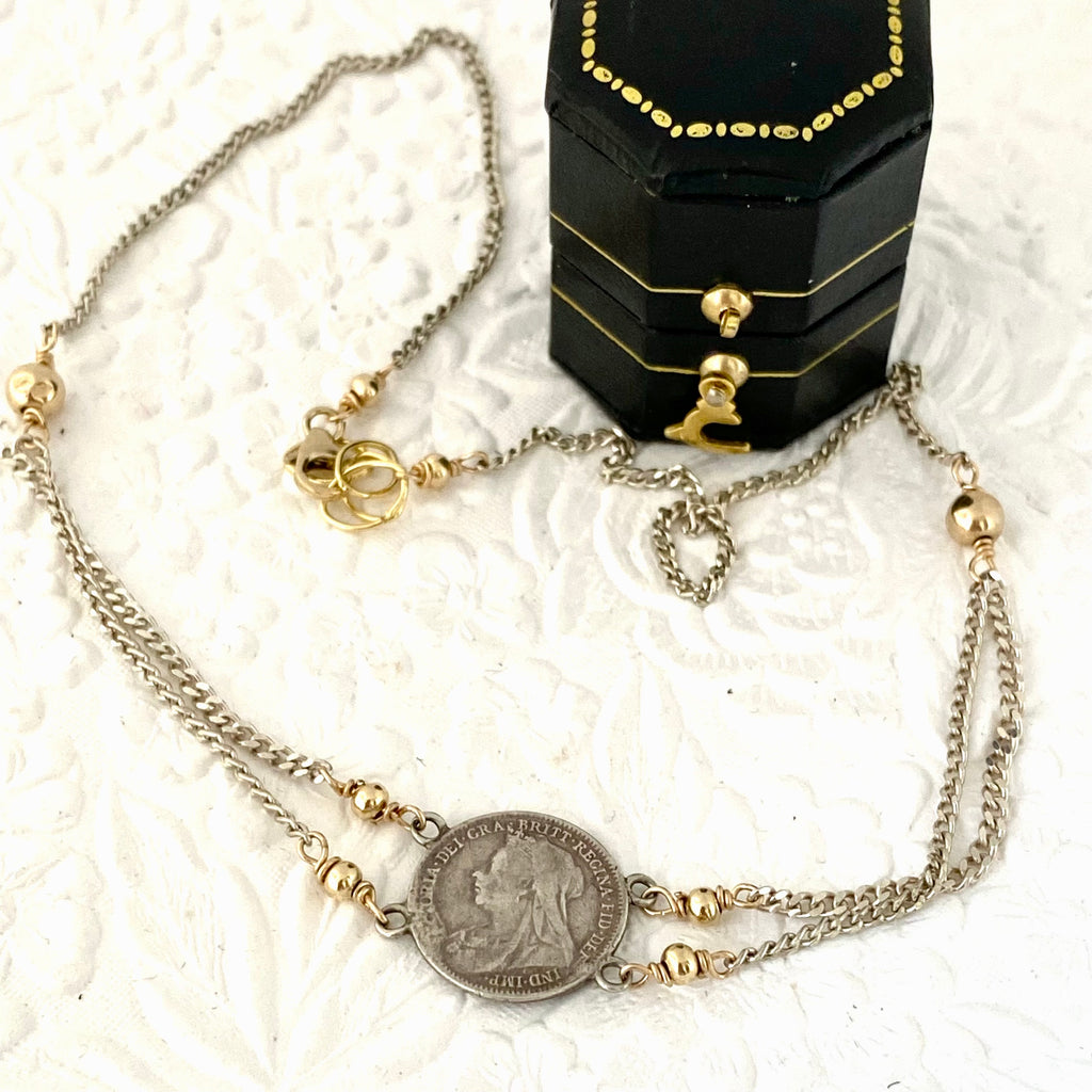 Leoni & Vonk 1899 coin necklace ona white background with a vintage box