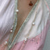 Cropped image of a woman wearing a white and pink kimono andLeoni & Vonk antique and pearl jewellery