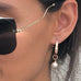 Model wearing Leoni & Vonk rose gold and white pearl drop earring and green Portmans shirt and Miu Miu sunglasses