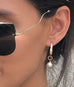 Model wearing Leoni & Vonk rose gold and white pearl drop earring and green Portmans shirt and Miu Miu sunglasses