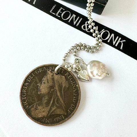 Leoni & Vonk British penny necklace on a sterling silver chain on a white background with Leoni & Vonk ribbon