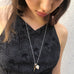 Cropped image of a dark haired girl wearing Leoni & Vonk jewellery and a blue dress