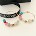 Leoni & Vonk colourful bead and gold hoop earrings with Leoni & Vonk ribbon
