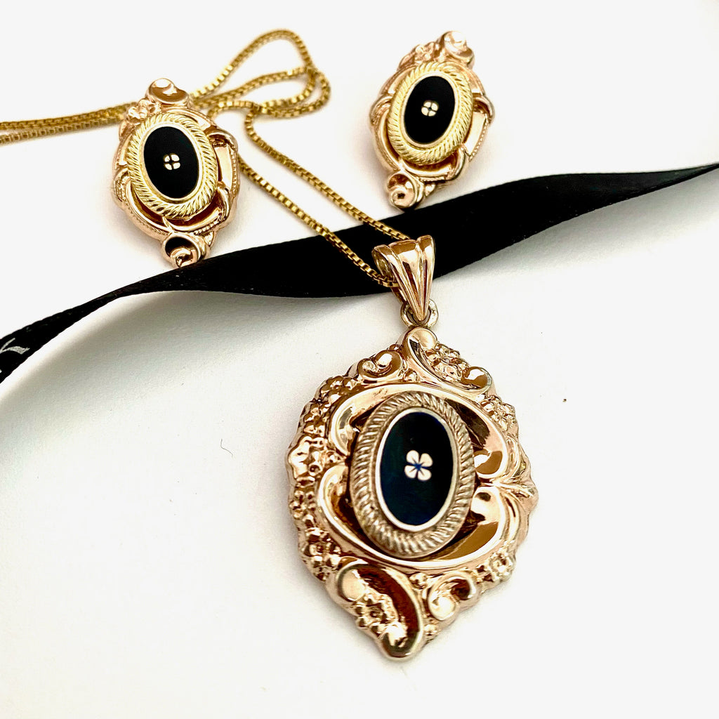Leoni & Vonk victorian style enamelled and gilt neckalce and earrings on a white background and black Leoni & Vonk ribbon