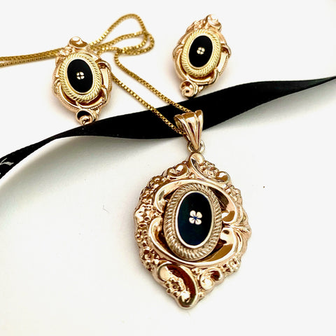 Leoni & Vonk victorian style enamelled and gilt neckalce and earrings on a white background and black Leoni & Vonk ribbon