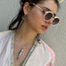 Dark haired model wearing white sunglasses and Leoni & Vonk vintage jewellery
