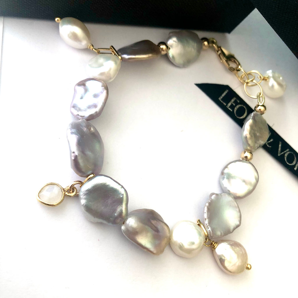 Leoni & Vonk keshi pearl charm bracelet with moonstone heart and freshwater pearl drops. It is on a white background with Leoni & Vonk ribbon.