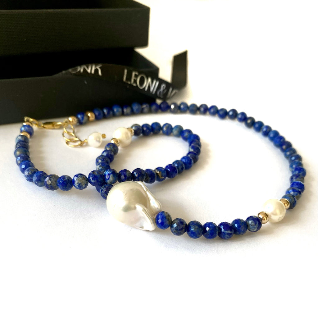 Leoni & Vonk lapis lazilu and baroque pearl neckacle on a white background with Leoni & Vonk ribbon