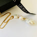 Leoni & Vonk triple pearl drop necklace on a white background with Leoni & Vonk ribbon.