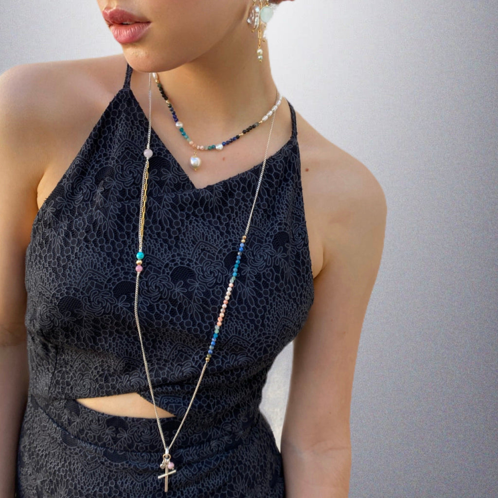 Cropped image of a dark haired girl wearing a blue dress and Leoni & Vonk jewellery