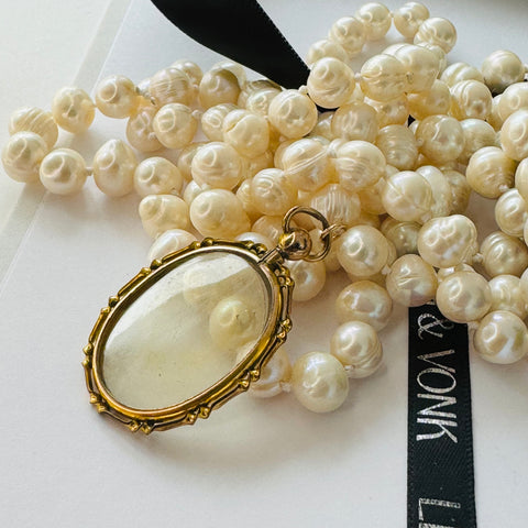 Leoni & Vonk long pearl and antique rolled gold photo locket on a white background with Leoni & Vonk ribbon