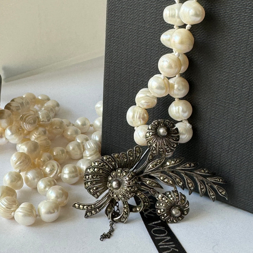 Leoni & Vonk vintage marcasite brooch and long pearl necklace on a black box and with Leoni & vonk ribbon