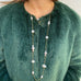IMage of a woman wearing a green fur coat and Leoni & Vonk long pearl and gold chain necklace.