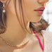 Cropped image of a dark haired girl looking to the left of the frame. She is wearing Leoni & Vonk pearl jewellery.