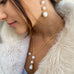 DArk haired girl looking to the left of the image. She is wearing a cream fur coat and Leoni 7 Vonk pearl jewellery.
