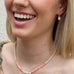 Blonde girl laughing wearing Leoni & Vonk pink opal jewellery. The image is cropped.