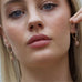 Blonde girl looking out at the camera wearing Leoni & Vonk pink opal earrings.