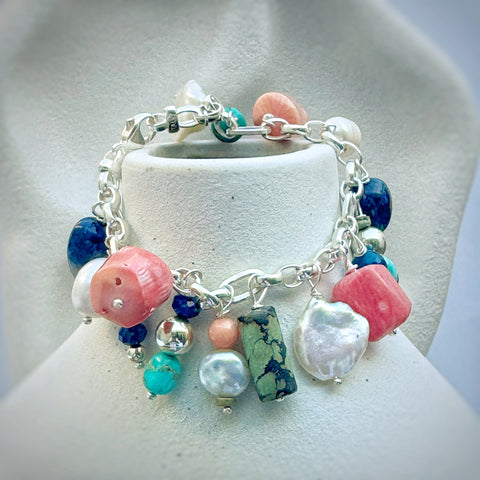 Leoni & Vonk multi pearl and semi precious stone charm bracelet  hanging on a white vase