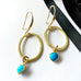 Leoni & Vonk gold and turquoise heart earrings on a white background with Leoni & Vonk ribbon