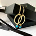 Leoni & Vonk gold and turquoise heart earrings on a white background with Leoni & Vonk ribbon