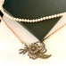 Leoni & Vonk pearl and vintage brooch necklace on a white background and with a black box