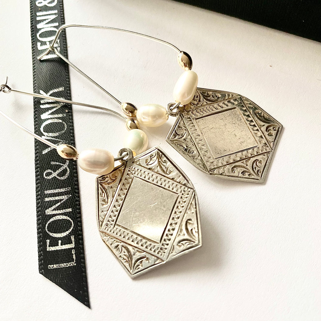 Leoni & Vonk vintage Stokes sterling silver medallion earrings on a white background and with Leoni & Vonk ribbon.