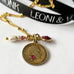Leoni & Vonk antique love token necklace on a white background with Leoni & Vonk ribbon