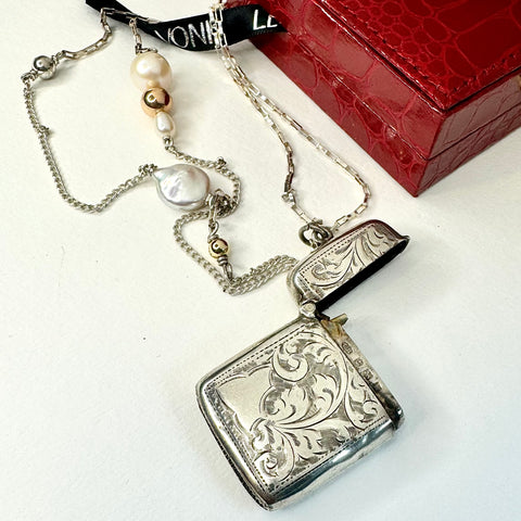 Leoni & Vonk 1909vesta case necklace on a white background and with a red box and Leoni & Vonk ribbon