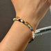 Cropped image of a womans hand wearing leoni & Vonk turquoise and lapis bracelet
