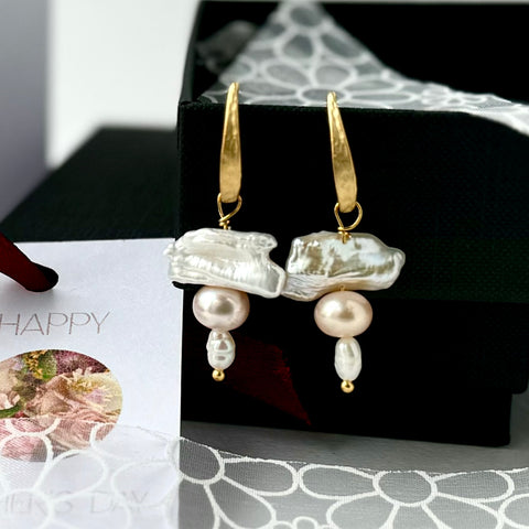 Leoni & Vonk gold and pearl stack earrings on a black box  with Leoni & Vonk and white flower ribbon