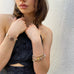 Cropped image of a dark haired girl wearing Leoni & Vonk bracelets and a blue dress.
