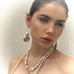 Image of a dark haired model wearing Leoni & Vonk jewellery. She has aher hair pulled back and is looking to the side.