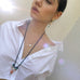 Dark haired model wearing Leoni & Vonk crystal charm necklace and a white shirt