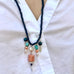 Cropped image of Leoni & Vonk crystal charm necklace on a white shirt