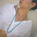Dark haired model wearing Leoni & Vonk jewellery and a white shirt