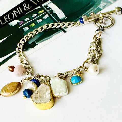 Leoni & Vonk sterling silver lapis fob clasp charm bracelet on a white background with a vintage postcard