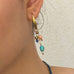 Cropped image of a dark haired girl wearing Leoni & Vonk charm earrings