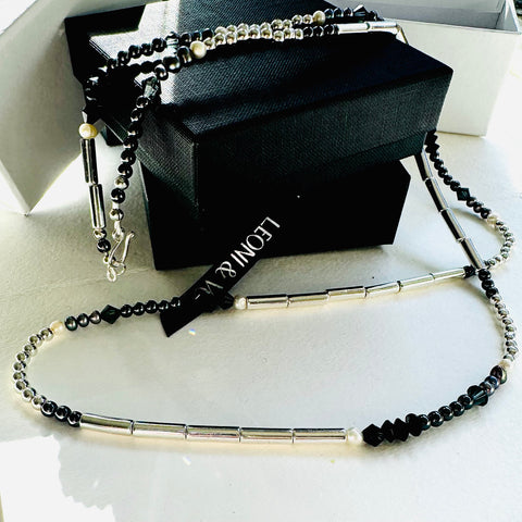 Leoni & Vonk hematite, pearl and crystal necklace on a white background and with a Leoni & Vonk box and ribbon.