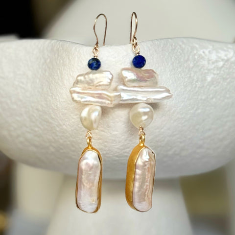 Leoni & Vonk long drop pearl earrings on a white textured vase
