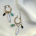 Leoni & Vonk gold hoop interchangeable earrings with howlite, pearl and sapphire charms on a white textured background