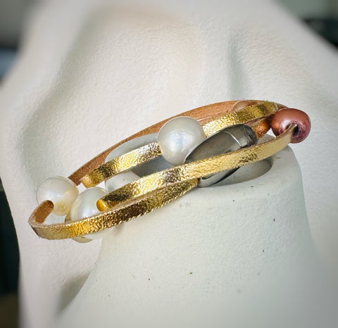 Leoni & Vonk gold leather bracelet on a white vase