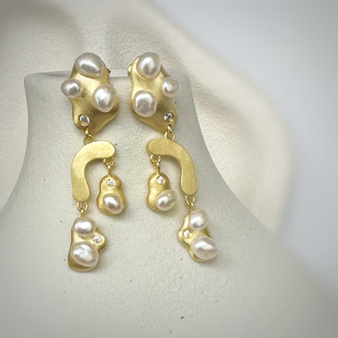 Leoni & Vonk gold, pearl and cubic zirconia earrings on a white vase