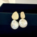 Leoni & Vonk Yi su gold and keshi pearl stud earrings on a black box