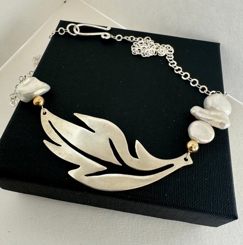 Leoni & Vonk leaf necklace on a black box