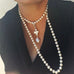 Cropped image of a woman wearing a blue top and Leoni & Vonk long pearl necklace